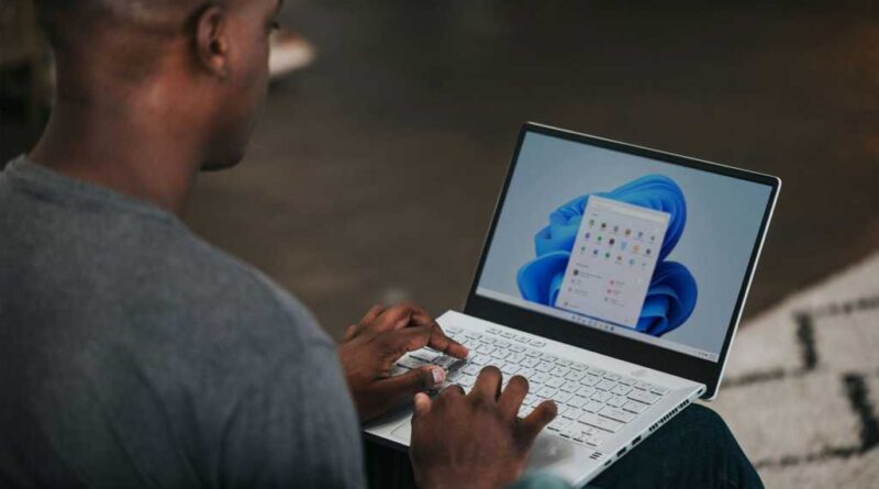 Man on Windows 11 laptop with apps selection