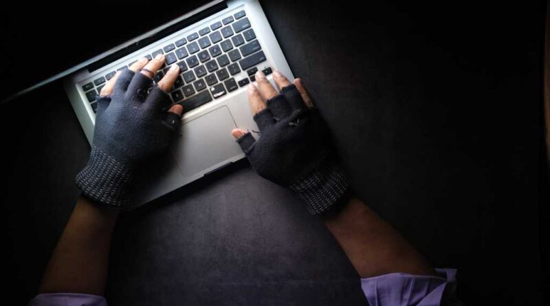hacker hands stealing data from laptop top down