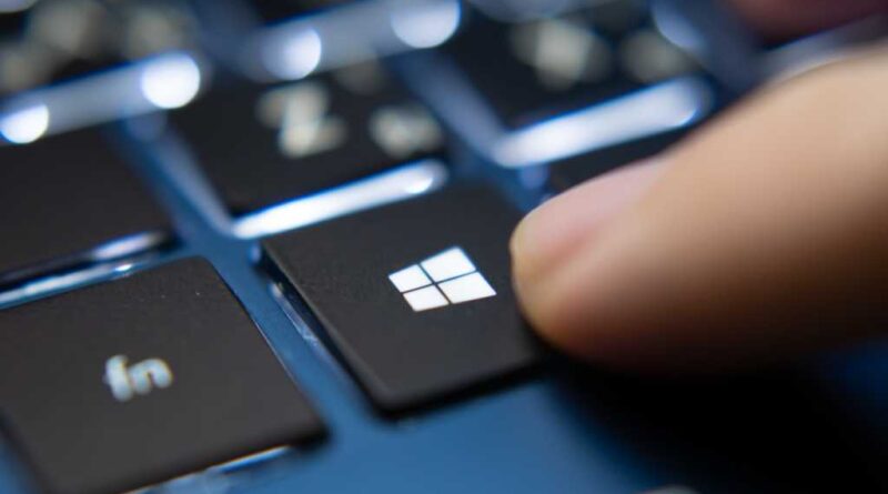 Closeup finger pressing Windows key on laptop keyboard