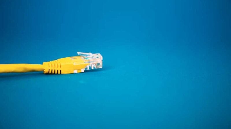 A yellow ethernet cable on a minimal blue background