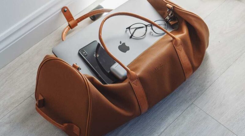 Duffel bag with iPhone, MacBook, and Airpods