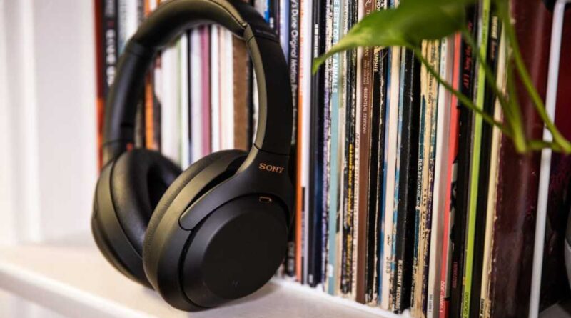a pair of sony over-the-ear headphones leaning against a rack of LP album covers