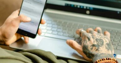 Man at a laptop with a phone in his hand