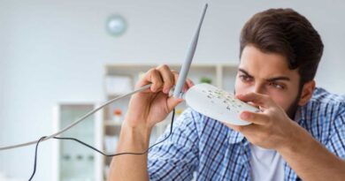 Mann checkt frustriert seinen WLAN-Router