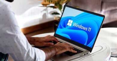 Windows 11 auf einem Laptop auf einem Kaffeetisch mit einem Mann mit Händen auf der Tastatur