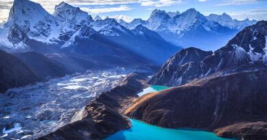 Dieses Microsoft Theme für Windows zeigt schneebedeckte Berge vor kristallklarem Wasser