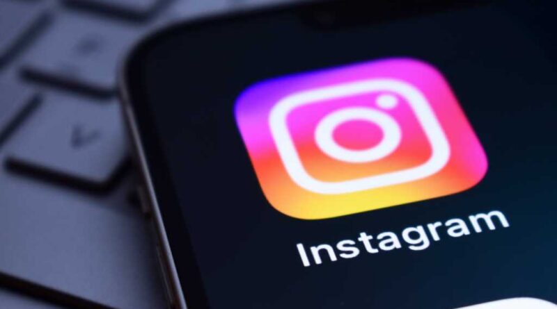 Instagram app icon on a phone screen on a laptop keyboard
