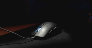 A computer mouse lit dramatically on a black mouse mat
