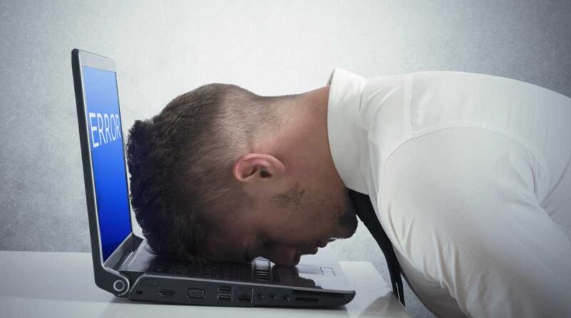 Windows Laptop Mann legt verzweifelt seinen Kopf auf die Tastatur