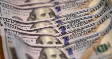 One-hundred US dollar bills lined up and stacked on top of each other