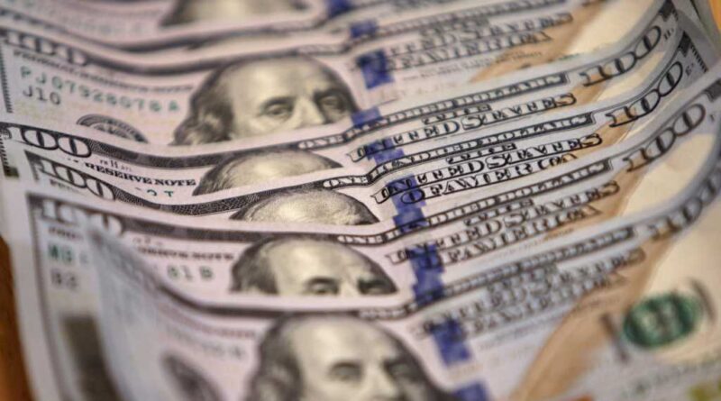 One-hundred US dollar bills lined up and stacked on top of each other