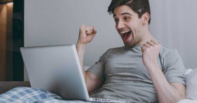 Laptop-Nutzer jubelt im Bett