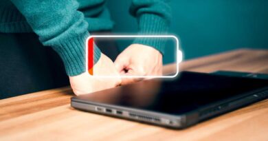 Laptop on wooden desk with empty battery icon indicator