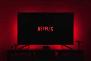 Netflix logo on a TV in a dark room with red backlighting