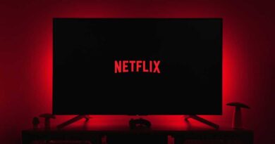 Netflix logo on a TV in a dark room with red backlighting