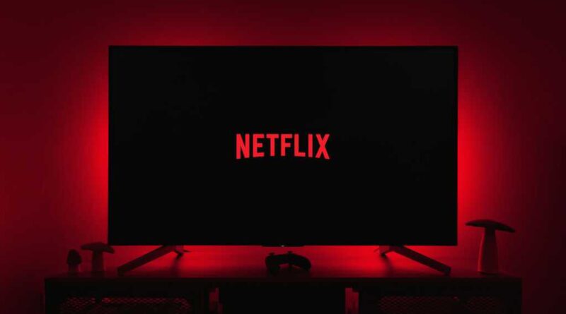 Netflix logo on a TV in a dark room with red backlighting