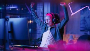 Gamerin jubelt vor Monitor.