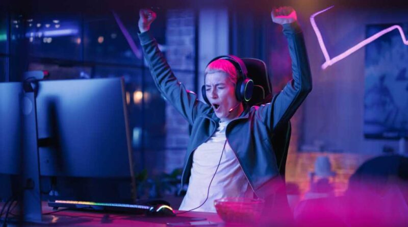 Gamerin jubelt vor Monitor.