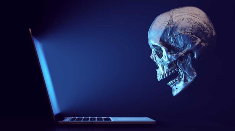 Totenkopf als Symbol für Hacker blickt ratlos auf Laptop-Bildschirm