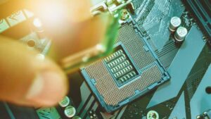 Fingers placing CPU processor chip into motherboard socket