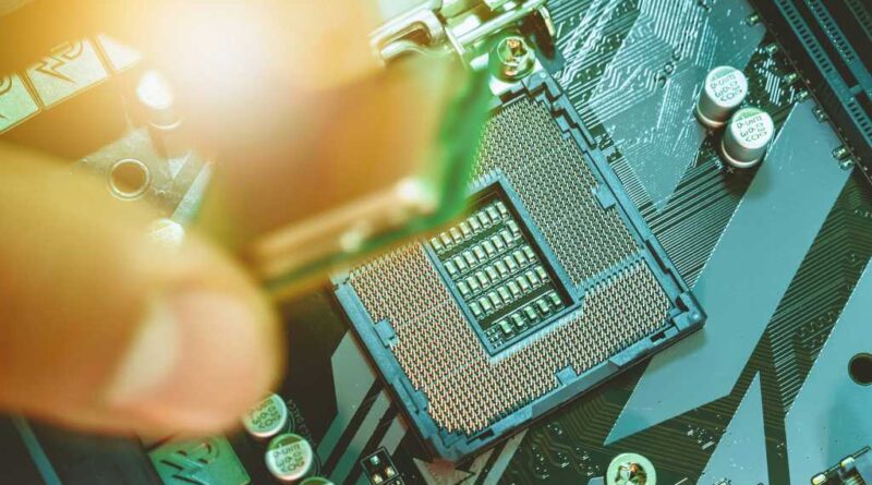 Fingers placing CPU processor chip into motherboard socket