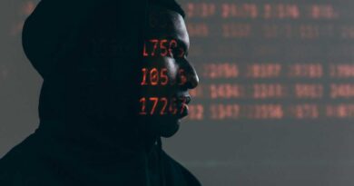 Hacker in a dark room with LED numbers lit on their skin