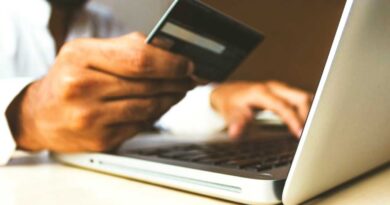 Man on laptop holding credit card making online purchase