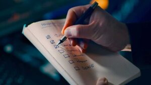 Pen checklist crossing off in front of a desktop PC setup