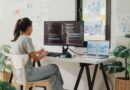 Woman working in home office at desk with laptop and monitor