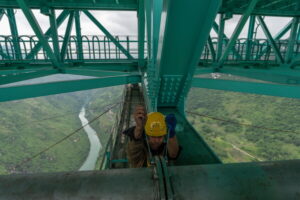 A worker tightens bolts on a pipe of the Huajiang Grand Canyon Bridge, considered to be the world’s highest bridge, in Anshun in southwestern China
