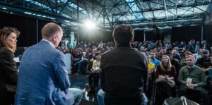 Three speakers face the crowd at TechCrunch Disrupt