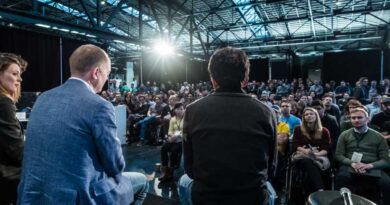 Three speakers face the crowd at TechCrunch Disrupt