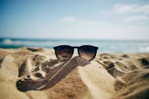 Sunglasses on top of a sand on a beach