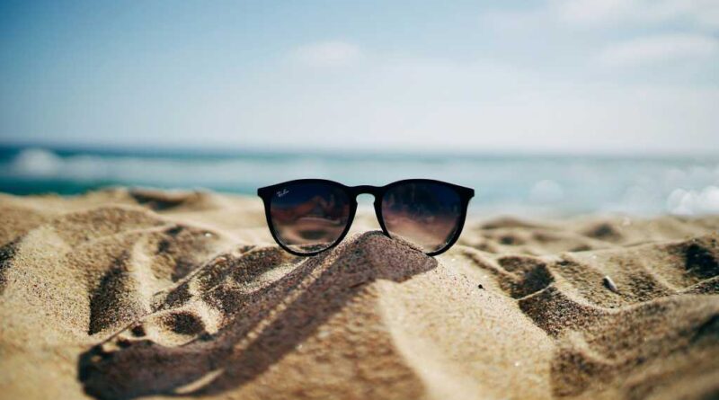 Sunglasses on top of a sand on a beach
