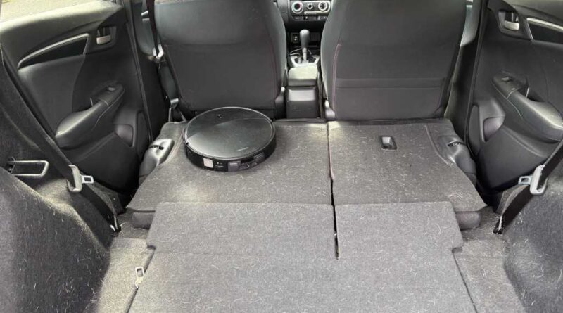 A robot vacuum "cleaning" the back of a car