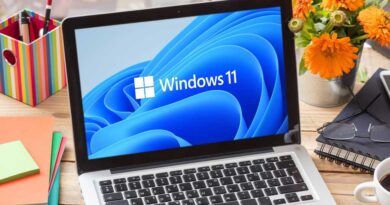 Windows 11 laptop on a wooden desk workstation
