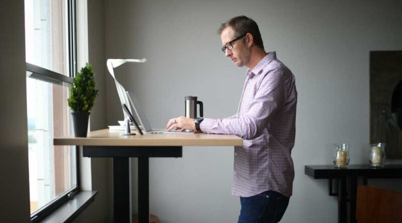 Man working from home with laptop on a standing desk