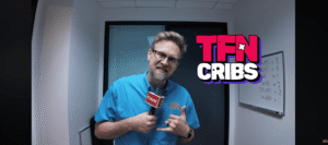 TFN Cribs logo superimposed over Adam Patrick Murray standing in the studio holding a microphone